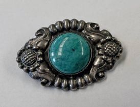 DANISH SILVER BROOCH WITH A POLISHED AMAZONITE ROUNDED TO CENTRE WITHIN A FLORAL BORDER BY KAY