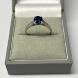 PLATINUM SET SAPPHIRE SINGLE STONE RING WITH DIAMOND SET SHOULDERS,