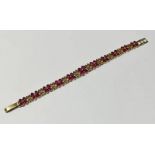 GOLD RUBY & DIAMOND SET BRACELET WITH PIERCED WORK DECORATION & CLUSTERS OF 4 RUBIES & SINGLE