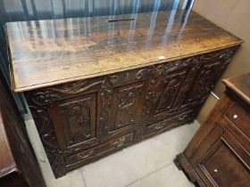 OAK CABINET WITH 2 PANEL DOORS WITH CARVED CLASSICAL SCENE DECORATION OVER 2 DECORATIVE CARVED