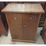 20TH CENTURY OAK CABINET WITH 2 PANEL DOORS OPENING TO SHELVED INTERIOR ON PLINTH BASE.