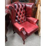 OX-BLOOD RED LEATHER BUTTONED WINGBACK ARMCHAIR ON SHORT- QUEEN ANNE SUPPORTS.