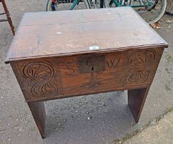 19TH CENTURY OAK STORAGE BOX WITH LIFT LID TOP & CARVED DECORATION TO FRONT INTIALLED 'SW'.