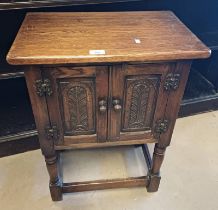 20TH CENTURY SMALL OAK CABINET WITH 2 PANEL DOORS WITH CARVED DECORATION ON TURNED SUPPORTS.