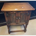 20TH CENTURY SMALL OAK CABINET WITH 2 PANEL DOORS WITH CARVED DECORATION ON TURNED SUPPORTS.