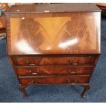 MAHOGANY BUREAU WITH FALL FRONT OVER 3 DRAWERS ON QUEEN ANNE SUPPORTS .