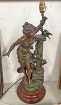 CAST METAL LAMP OF FIGURE STANDING BESIDE A PILLAR,