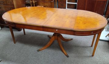 YEW EXTENDING DINING TABLE WITH 2 EXTRA LEAVES ON CENTRE PEDESTAL WITH 4 SPREADING SUPPORTS.
