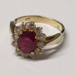 14K GOLD RUBY & DIAMOND CLUSTER RING THE OVAL RUBY SET WITHIN A SURROUND OF 12 DIAMONDS APPROX 0.