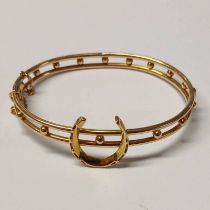 18CT GOLD HINGED BANGLE SURMOUNTED WITH HORSE SHOE, STAMPED 18 - INNER DIAMETER 6.2 CM , 13.