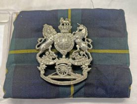 ABERDEENSHIRE ARTILLERY VOLUNTEERS HELMET PLATE IN A PLASTIC CASE MOUNTED IN TARTAN