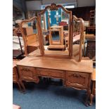 CONTINENTAL OAK DRESSING TABLE WITH SHAPED TRIPTYCH MIRROR OVER CENTRALLY SET SINGLE DRAWER FLANKED