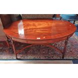 CROSSBANDED MAHOGANY OVAL COFFEE TABLE ON REEDED SUPPORTS WITH X - UNDERSTRETCHER.