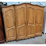 CONTINENTAL OAK 4 DOOR WARDROBE WITH DECORATIVE SHAPED CORNICE ON CABRIOLE SUPPORTS.