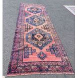 IRANIAN RUNNER WITH WASHED RED GROUND TRIPLE MEDALLION DESIGN,