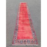 RED GROUND IRANIAN RUNNER ALL OVER PLAIN FIELD WITH SURROUNDING BORDER 450 X 85CM