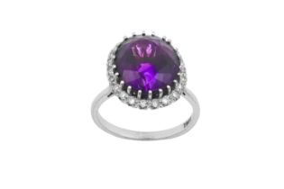 An Amethyst and Diamond Cluster Ring the oval cut amethyst within a border of eight-cut diamonds, in