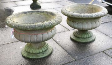 A Pair of Reconstituted Stone Garden Urns, of compressed campana-shaped form, with moulded rims