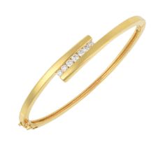 An 18 Carat Gold Diamond Bangle the yellow crossover motif with seven round brilliant cut diamonds