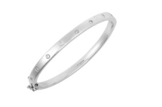 A 9 Carat White Gold Diamond Hinged Bangle inset with eight round brilliant cut diamonds, to a plain