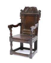 A Joined Oak Wainscot-Type Armchair, circa 1670, the scrolled and carved top rail above a fielded