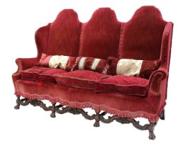 A William & Mary-Style Three-Seater Wing-Back Sofa, early 20th century, covered in red velvet,