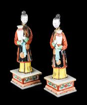 ~ A Pair of Chinese Porcelain "Nodding Head" Figures, Qianlong, each modelled standing holding a