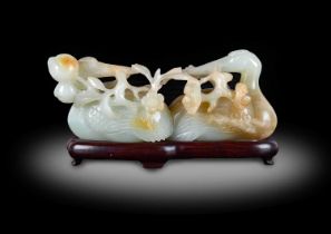 ~ A Chinese Pale Celadon and Russet Jade Group, Qing Dynasty, late 18th/19th century, as two opposed