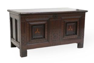 A 17th Century Joined Oak Chest, the hinged lid enclosing a vacant interior above a nulled frieze