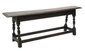 A Charles II Joined Oak Form, the moulded top with pegged joints above a chip-carved moulded