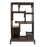 A Chinese Export Carved Hardwood Display Cabinet, early 20th century, the framework carved as a