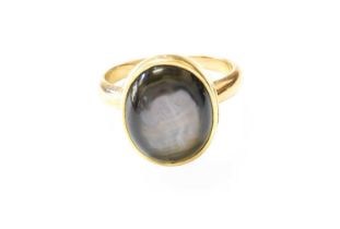 A Cat's-Eye Stone Ring, the oval cabochon cat's-eye stone in a yellow rubbed over setting, to a