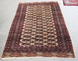 Pakistani "Bukhara" Rug, the sand field with three columns of quartered guls enclosed by multiple