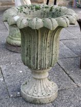 A Cast Composition Garden Urn, moulded with over lapping leaves, raised on spreading circular