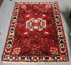 Kashgai Rug, the blood red field of tribal and zoomorphic motifs enclosed by ivory borders of