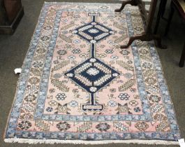 Heriz Rug, North West Iran, circa 1930, the faded rose pink field with two stepped indigo medallions