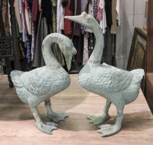 A Pair of Cast Metal Garden Statues, formed as geese in differing poses and with verdigris