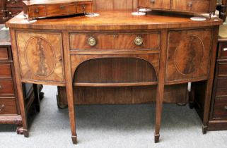 A George III Mahogany bow front sideboard, crossbanded, with tambour fronted cupboard and on