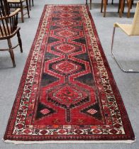 North West Persian Runner, the charcoal field with a column of stepped medallions enclosed by