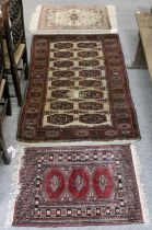 Afghan Tekke Rug, the ivory field with two columns of guls enclosed by madder borders, 152cm by