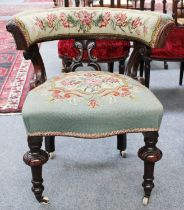 A Victorian Needlework Upholstered Walnut Framed Open Armchair, with horseshoe back, moving on