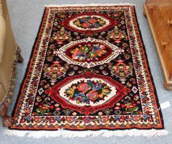 Hamadan Rug, the field with three panels of semi-naturalistic flowers enclosed by ivory borders,