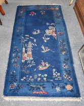 Chinese Rug, the deep indigo field with boatmen and a pagoda enclosed by borders of trees and