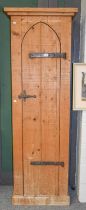 A Narrow Pine Cupboard, with single arch door and iron strap work, 69cm by 38cm by 202.5cm Very