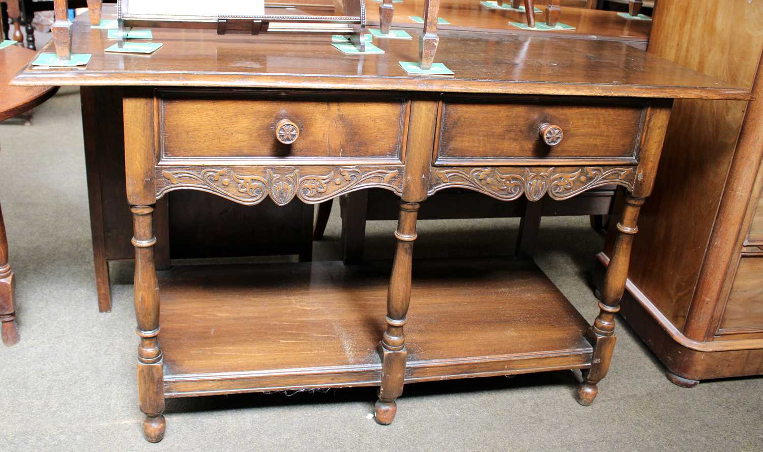 A Waring & Gillow Ltd Oak Two Drawer Side Table, with scroll carved apron, turned supports and under