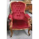 A Victorian Oak-Framed Armchair, circa 1870, recovered in buttoned red velvet, with a moulded and