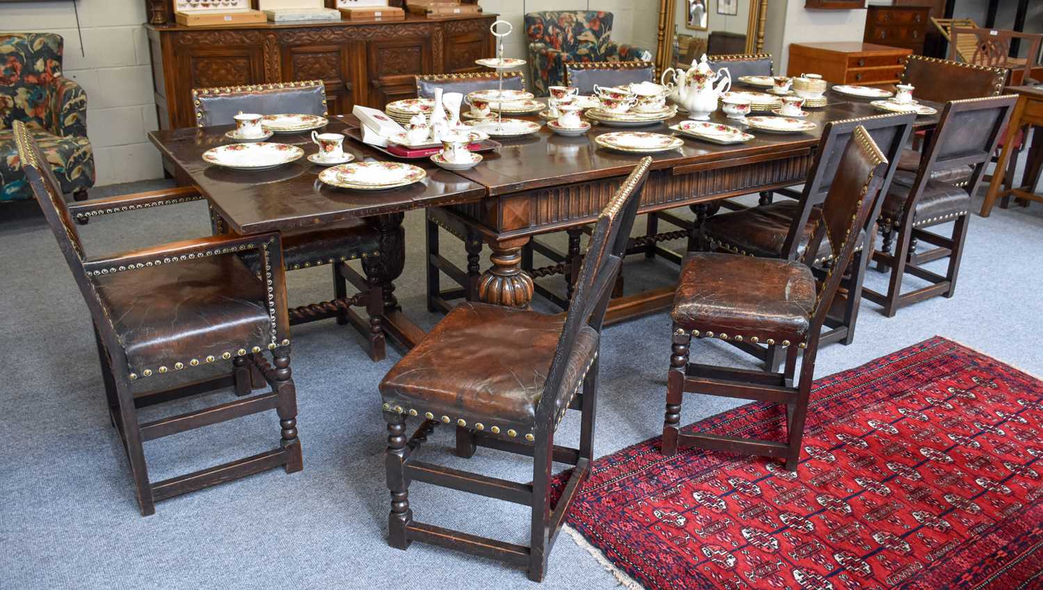 An Oak Draw Leaf Dining Table, on carved and gadrooned cup and cover supports, joined by a trestle