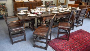 An Oak Draw Leaf Dining Table, on carved and gadrooned cup and cover supports, joined by a trestle