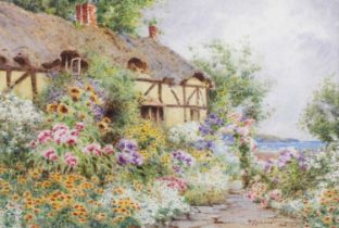 Attributed to John Abernethy Lynas-Gray (fl.1890-1920) Coastal thatched-cottage with garden in