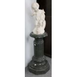 A Marble Figure of a Putto and Dolphin, 42cm high on a varigated green marble column, 61cm high (